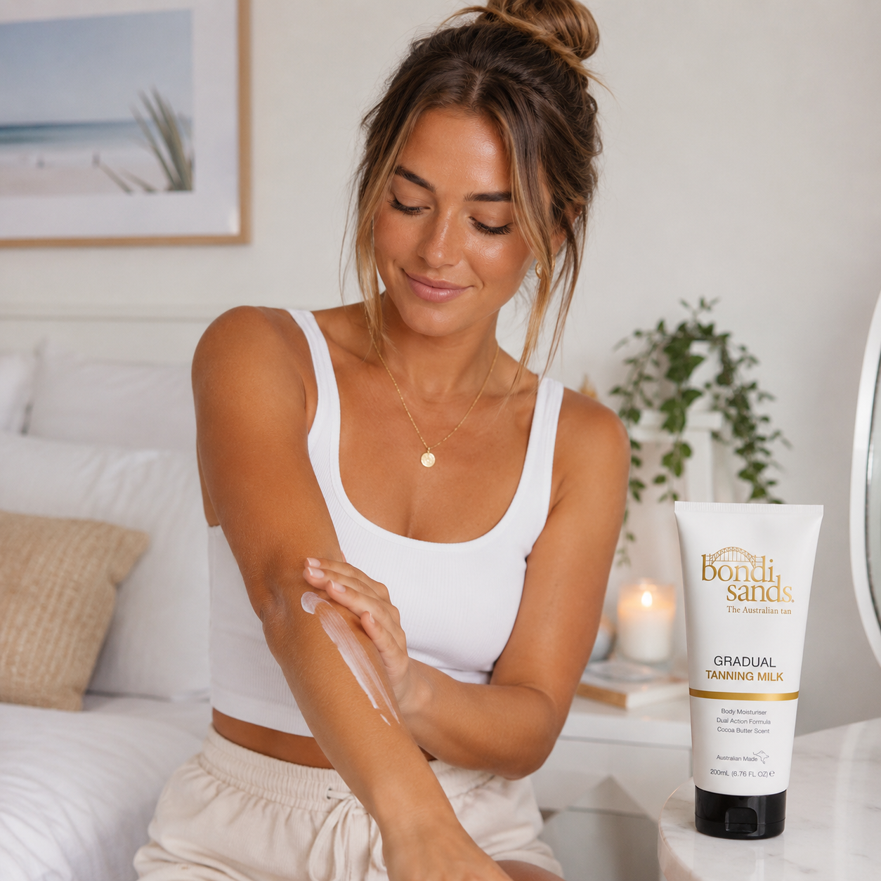 Woman applying gradual tanning milk after shower